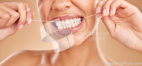 Image of Flossing, smile and a woman with dental care for teeth isolated on a studio background. Happy, healthcare and the mouth of a girl with a routine oral hygiene cleaning, treatment and tooth floss