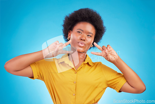 Image of Happy, motivation and black woman with peace sign, inspiration and success against blue studio background. African American female, lady and hand gesture for emoji, silly and v symbol with happiness