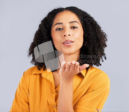 Image of Flirty, happy and a portrait of a woman blowing kiss isolated on a studio background. Love, smile and a flirtatious girl with a loving, cute and romantic gesture on a backdrop for expression