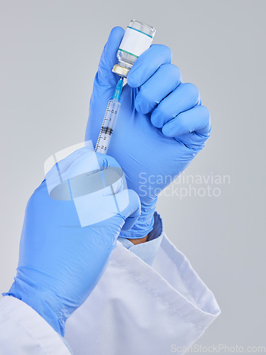 Image of Vaccine vial, needle and doctor hands in studio for safety, healthcare and pharmaceutical medicine. Closeup person, vaccination and injection bottle for virus, immunity and medical antibiotics drugs