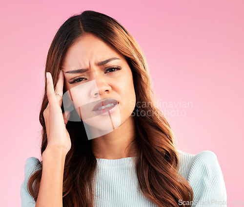 Image of Headache, stress and pain, portrait of woman in studio, tired and depression isolated on pink background. Mental health, burnout and depressed hispanic model with hand on head and temple massage.