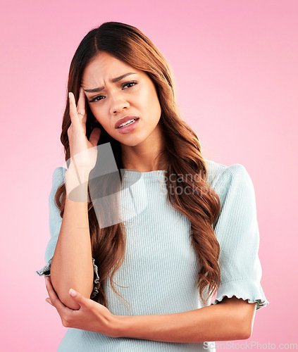 Image of Stress, anxiety and portrait of woman with headache in studio, tired and exhausted on pink background. Mental health, burnout and depressed hispanic model with hand on head in pain and temple massage