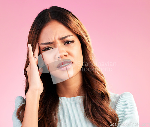 Image of Stress, burnout and woman with headache in studio, tired or exhausted on pink background. Mental health, depression and anxiety, overworked hispanic model with hand on head in pain and temple massage