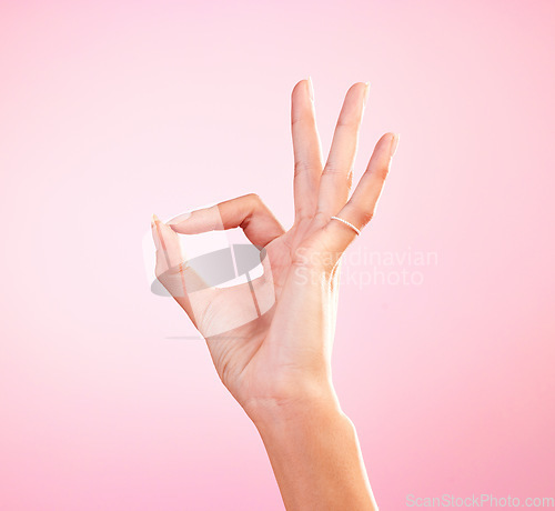 Image of Hand, perfect and ok sign or emoji in studio for motivation, review and yes or agreement for support. Woman icon, gesture or fingers for approval, communication or decision on mockup pink background