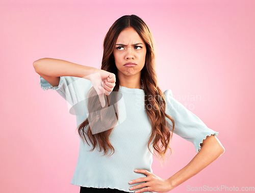 Image of Sad, hands and thumbs down by woman in studio for bad review, complaint or disappointed on pink background. Frown, finger and emoji expression by girl with vote for wrong, bad news or reject isolated