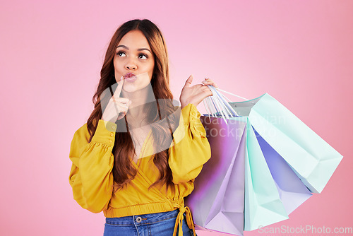 Image of Woman thinking about shopping purchase, paper bag and retail with fashion sale on pink background. Customer experience, service and product choice, thoughtful female in studio and discount at shop