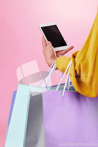 Image of Phone screen, shopping bag and hands of woman isolated on pink background online shopping, ecommerce and retail. Fashion person on mobile app, cellphone or smartphone for mockup space in studio