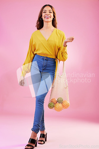 Image of Shopping, portrait and woman nutritionist with fruit in studio for health, diet and healthy living on pink background. Face, groceries and happy girl customer with organic product, nutrition or detox