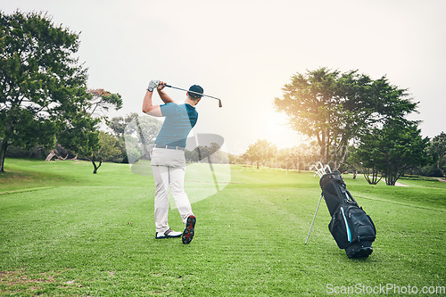 Image of Golf, stroke and training with a sports man swinging a club on a field or course for recreation and fun. Golfing, grass and hobby with a male golfer playing a game on a green during summer