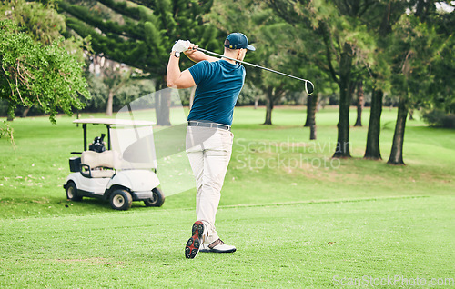 Image of Golf, stroke and grass with a sports man swinging a club on a field or course for recreation and fun. Golfing, hobby and training with a male golfer playing a game on a green during summer