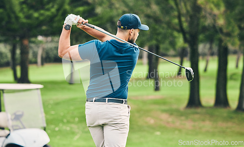 Image of Golf, training and hobby with a sports man swinging a club on a field or course for recreation and fun. Golfing, grass and stroke with a male golfer playing a game on a green during summer