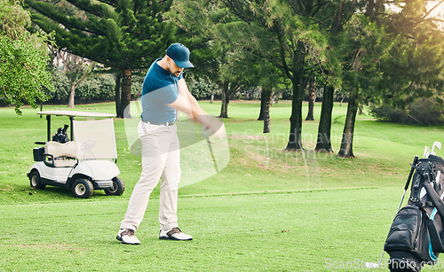 Image of Golf, stroke and hobby with a sports man swinging a club on a field or course for recreation and fun. Golfing, grass and training with a male golfer playing a game on a green during summer
