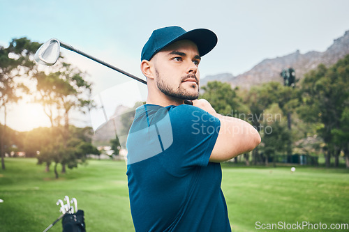 Image of Golf, focus and hobby with a sports man swinging a club on a field or course for recreation and fun. Golfing, grass and stroke training with a male golfer playing a game on a green during summer