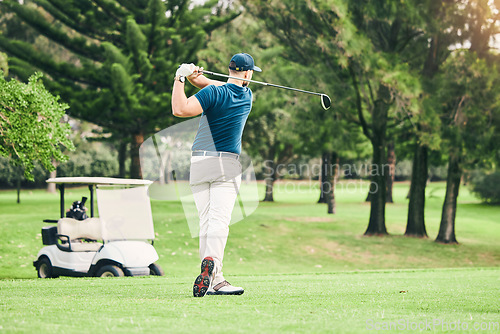 Image of Golf, stroke and focus with a sports man swinging a club on a field or course for recreation and fun. Golfing, grass and training with a male golfer playing a game on a green during summer