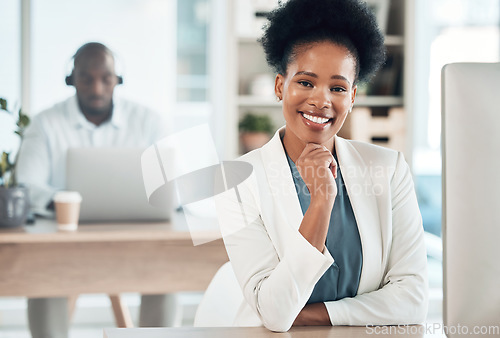 Image of Happy, success and portrait of a businesswoman in the office with a computer working on a project. Happiness, smile and African female corporate manager sitting at her desk with a pc in workplace.