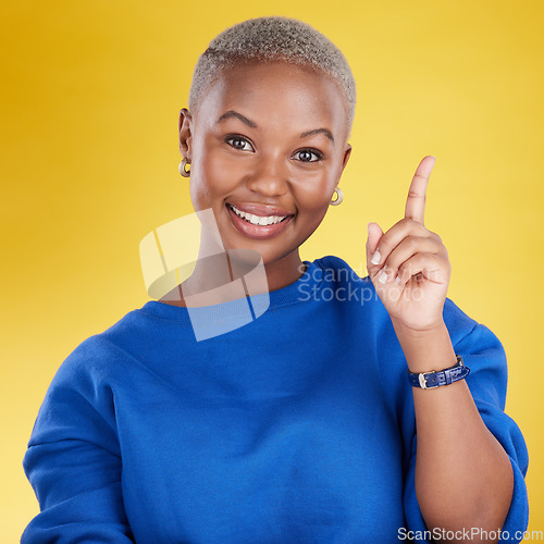 Image of Smile, portrait and black woman in studio pointing up at product placement, mockup or information. Deal, promotion or announcement, happy model showing info space or notification on yellow background