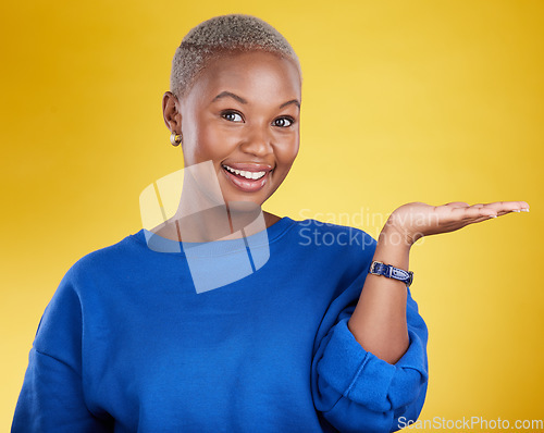 Image of Portrait, smile and black woman with product placement palm in studio isolated on a yellow background. Mockup face, happy and African female with hand for advertising, marketing or branding space.