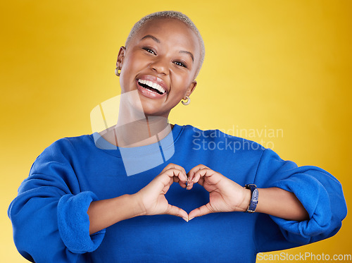 Image of Heart hands, portrait and happy black woman in studio, background and color backdrop for emoji. Smile, female model and finger shape for love, thank you and support of peace, care or sign of kindness