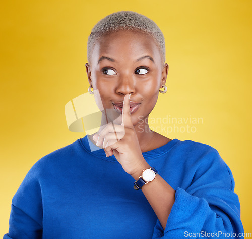 Image of Secret, face and black woman with finger on lips in studio, background and privacy of drama news. Female model, silence and quiet on mouth, shush and gossip in whisper, emoji or confidential surprise