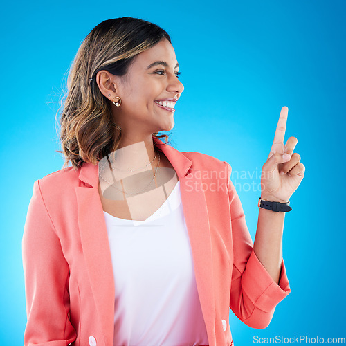 Image of Smile, mock up and Indian woman in studio pointing up for product placement, mockup or information. Deal, promotion or announcement, happy model showing info space or notification on blue background.