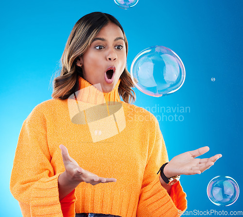 Image of Surprise, shock and bubble with indian woman in studio for soap, positive and satisfaction. Magic, creative and holding with female isolated on blue background for bright, cute and entertainment