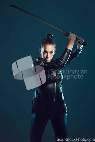 Image of Woman, warrior and vigilante in cosplay with sword ready for battle, war or game against a dark studio background. Female in black costume or hero with guns and blade for halloween or super power