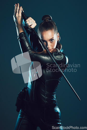 Image of Woman, warrior and vigilante in cosplay with sword for dangerous battle, war or game against dark studio background. Portrait of female in black widow costume with blade for halloween or hunger games