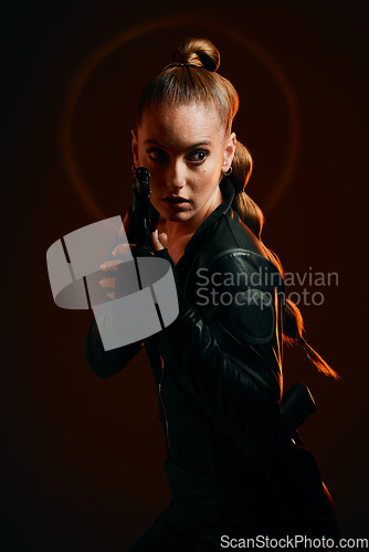 Image of Woman, warrior and gun to fight in studio for action and safety from danger on dark background. Strong female model, assassin or agent in scifi cosplay costume with weapon for action and defense