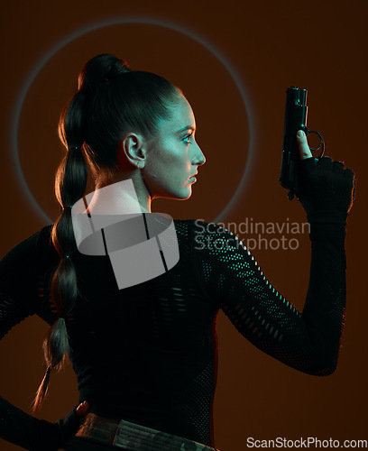 Image of Dark, assassin and a woman with a gun for action isolated on a studio background. Mission, warrior and a mafia agent with a weapon for protection, security and combat on a backdrop for a fight