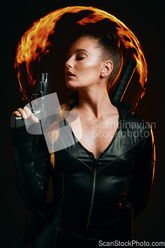 Image of Woman, warrior and vigilante in cosplay with gun ready for battle, war or game against a dark studio background. Female in black superhero costume with guns or weapon for halloween outfit