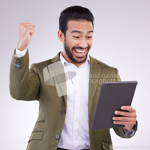 Image of Success, winning and man on tablet isolated on studio background fist pump for business news or online bonus. Happy asian person or winner on digital tech with celebration for sale, prize or giveaway