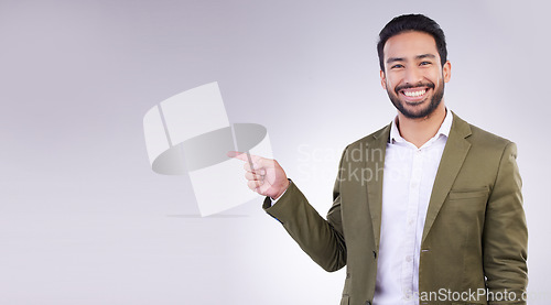 Image of Happy businessman, pointing and mockup for product placement, marketing or advertising against a white studio background. Employee man with smile showing point of advertisement, news or notification