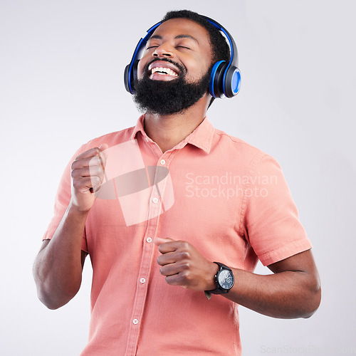 Image of Music headphones, dance and happy black man streaming song for studio fun, freedom and wellness. Dancing energy, audio podcast and person listening to radio, media sound or track on white background