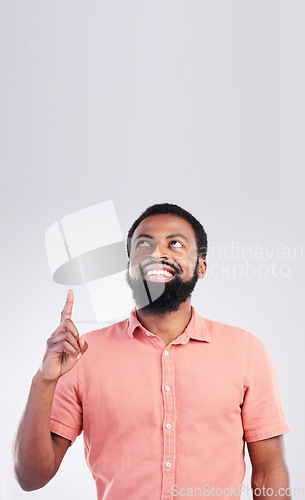 Image of Point, mockup space and black man looking up with hand gesture for product placement, advertising and sign. Happy, studio and male smile on white background pointing for choice, branding and showing