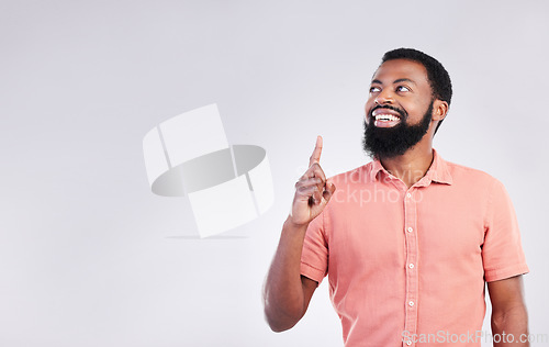 Image of Point, studio and black man with mockup space and hand gesture for product placement, advertising and sign. Happy, smile and male thinking on white background pointing up for choice, branding or show