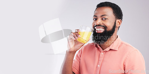 Image of Orange juice, portrait and happy black man drinking with glass for hydration, liquid detox or weight loss. Vitamin C benefits, male nutritionist beverage and studio person on mockup gray background