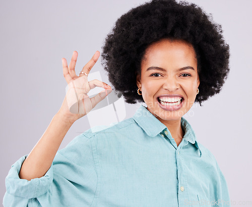 Image of Woman, afro and portrait smile with ok sign for satisfaction, approval or agreement against gray studio background. Happy female smiling and showing okay hand emoji, symbol or gesture for perfection