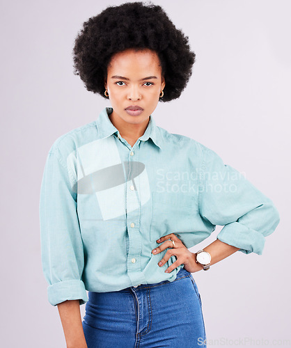 Image of Portrait, serious and black woman in studio, assertive and empowered posing against white background. Face, confident and young female with attitude, fierce or focus mindset while standing isolated