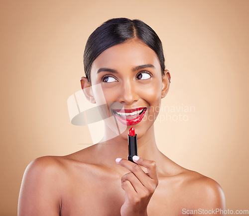 Image of Makeup, red lipstick and beauty of a woman in studio for cosmetics, face glow and shine product. Indian female model thinking on beige background about skin, facial self care and lips with color idea