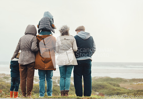 Image of Family hiking outdoor, generations at beach together with nature view and back, spending quality time in winter. Grandparents, parents and children, love and care with people at the coast