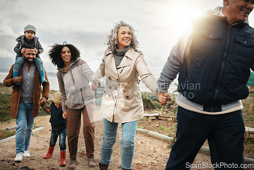 Image of Family, travel and adventure outdoor holding hands with children, parents and grandparents with flare. Men, women and kids walking together in nature with support, happiness and care for bonding time