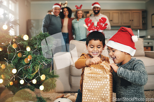 Image of Christmas, curious and children opening gifts, looking at presents and boxes together. Smile, festive and kids ready to open a gift or present under the tree for celebration of a holiday at home