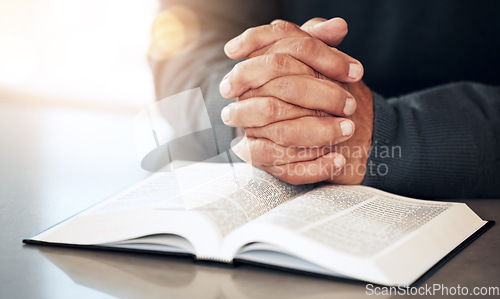 Image of Bible, hands and prayer of a man reading christian text for spiritual healing and religion. Lens flare, hand closeup and praying of a person with peace and a book for praise, support and hope