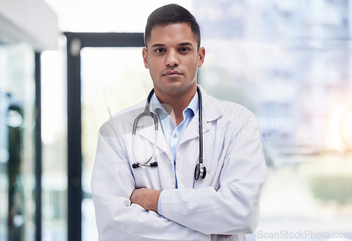Image of Portrait, man and doctor with arms crossed, focused and confident in hospital, clinic and surgery. Serious, proud and young medical worker in lab coat for healthcare services, wellness and commitment