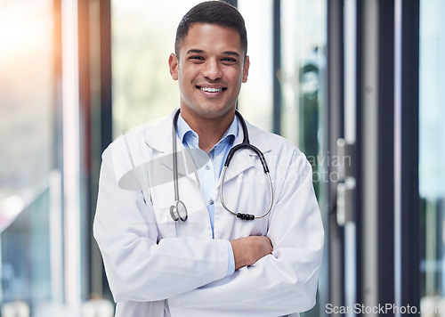 Image of Portrait, man and happy doctor with arms crossed, stethoscope and confident surgeon in hospital. Proud young healthcare worker smile in lab coat, medical services and surgery trust in wellness clinic