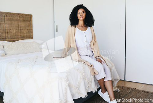 Image of Black woman relax, bedroom and home interior of a young female sitting on a bed feeling relax. House, morning and person calm on a blanket and duvet on a mattress getting ready for a nap and day rest