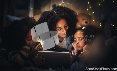 Image of Tablet, night a mother reading to her children in a tent while camping in the bedroom of their home together. Black family, story or kids with a woman storytelling to her kids at bedtime for bonding