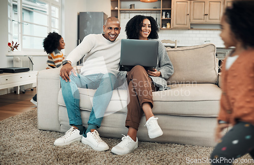 Image of Parents, family and kids playing in a home or house with mom and dad working on laptop and spending quality time together. Happy, playful and young couple or mother and father watching children play