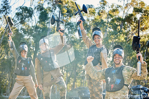 Image of Team, paintball and portrait in celebration for winning, victory or achievement on the battlefield together in nature. Group of people enjoying win, success or teamwork with guns in the air for sport