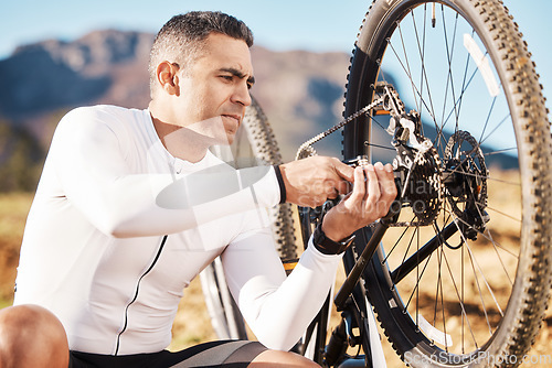 Image of Cycling, repair and wheel with man and focus for sports, wellness and fitness training. Insurance, safety and tire change with cyclist fixing mountain bike on trail for broken, puncture and check